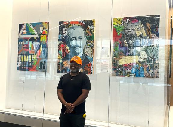 Artist Joseph Boyd in front of his exhibit of Robert Church portraits at the Renasant Convention Center.