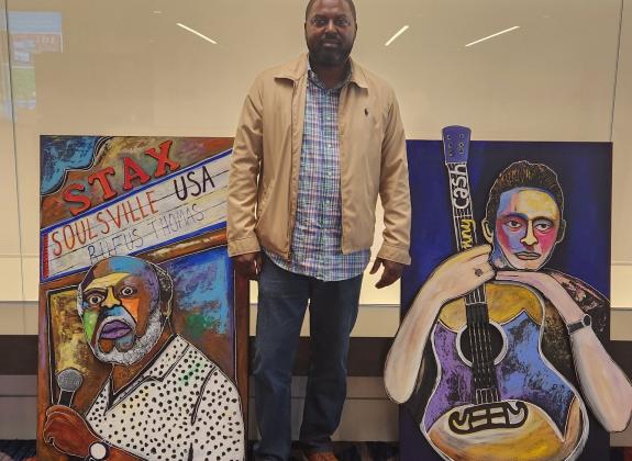 Artist Kelvin Baldwin next to his 3-d-style works at Renasant Convention Center.